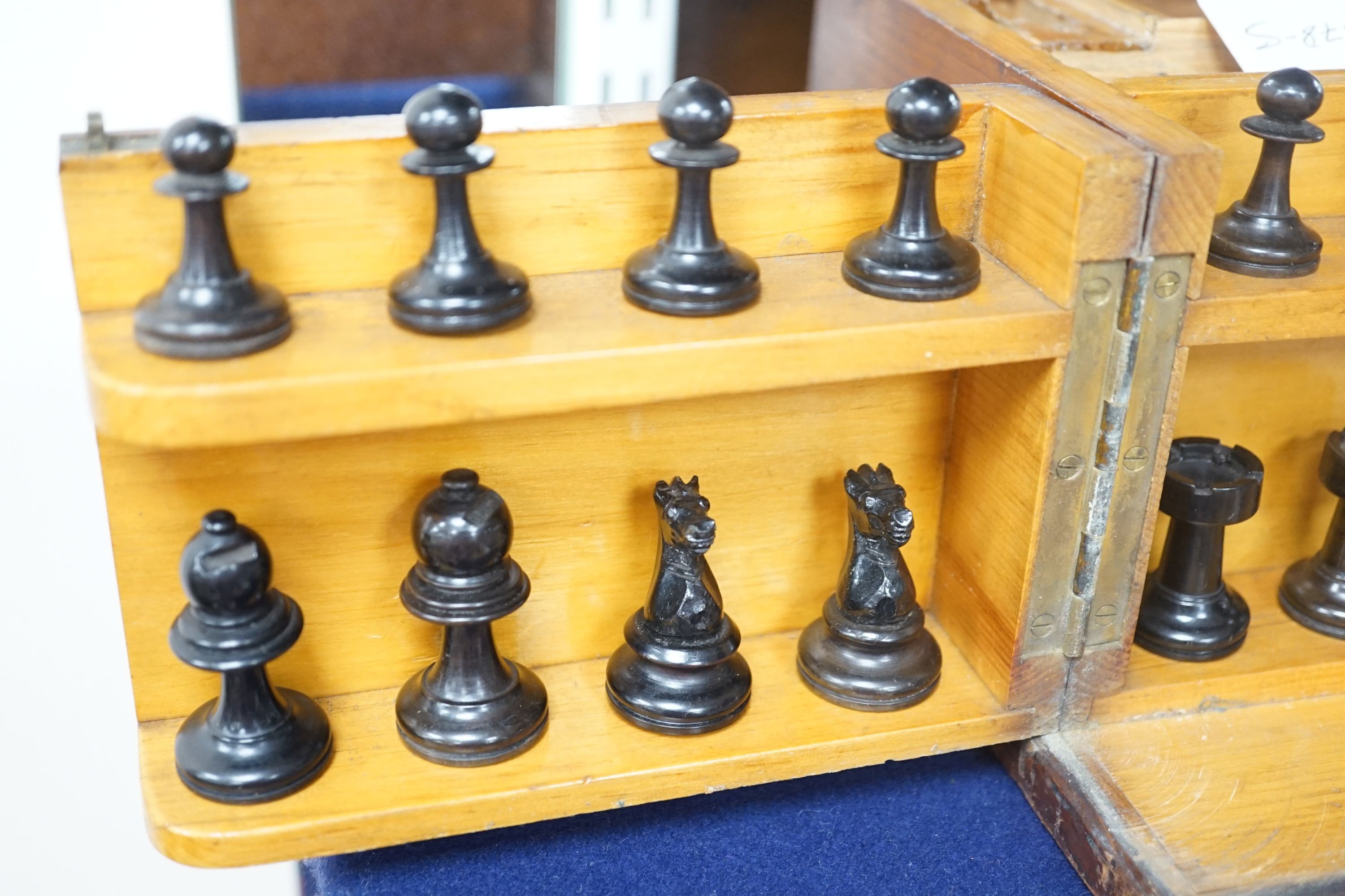 A 19th century mahogany games compendium with turned wood chess pieces and lead jockey and horse pieces